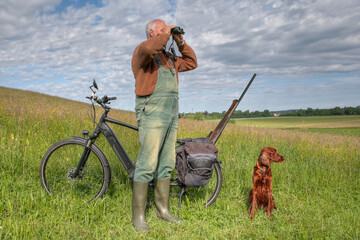 Ecological hunter is on the way in his hunting ground with his bicycle and his Irish Setter hunting...