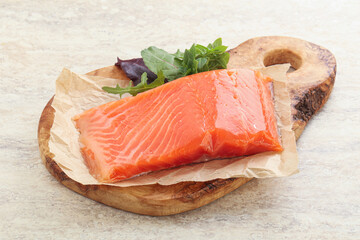 Raw salmon fillet over board