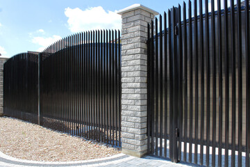 a neat black metal fence is an excellent solution for private development
