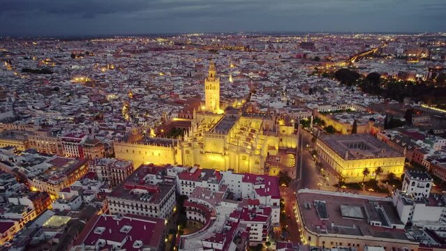Flying around the famous gothic Cathedral in Seville at night, Andalusia, Spain