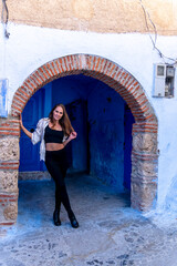 Fototapeta na wymiar A Model Poses In The Famous City Of Chefchaouen Also Known As The Blue Pearl