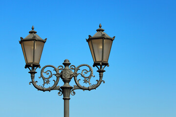 Fototapeta na wymiar vintage urban lighting mast with two lantern heads 