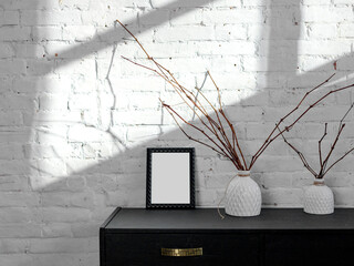 Black frame on a tusba against a white brick wall. sunlight. interior