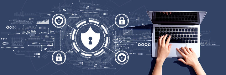Cyber security theme with person using a laptop computer