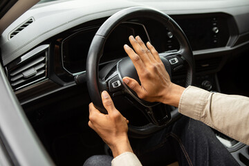 Man driving a car with hand on horn button