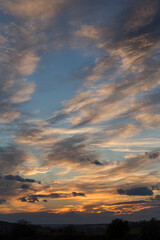 Fototapeta premium Landscape with bloody sunset. Panorama. Tragic gloomy sky. The last glimpses of the sun through the cirrus clouds.