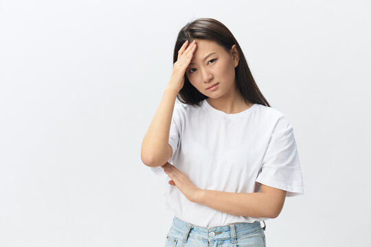 Migraine. Side view of unhappy suffering from headache tanned beautiful young Asian woman touching forehead posing isolated on white background. Injuries Poor health Illness concept. Cool offer Banner