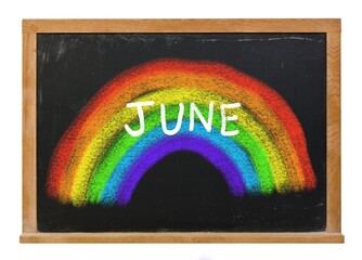 Colorful chalk rainbow with June written in white chalk on a black chalkboard isolated on white