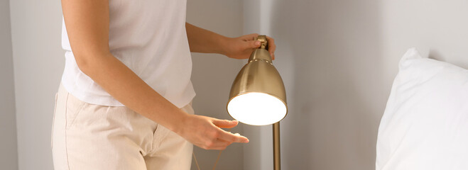 Woman with glowing lamp in bedroom