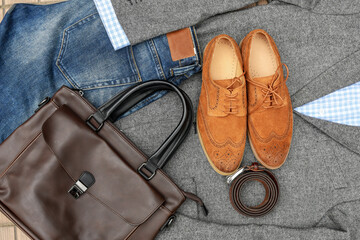 A pair of brown suede derby shoes, blue jeans, leather and bag belt with grey tweed blazer. Casual...