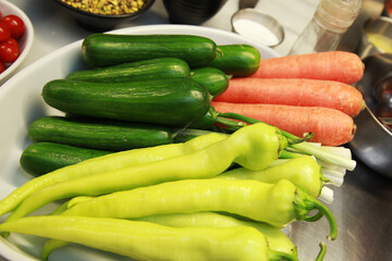Fresh vegetables (carrots, cucumbers and charliston pepper) on the plate.