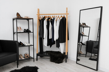Interior of stylish dressing room with female clothes, shoes and mirror