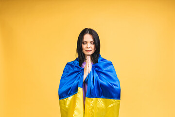 Stop war in Ukraine! Portrait of sad agressive angry woman holding in hands Ukrainian flag isolated...