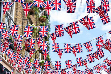 Union Jack flags on the street during queens jubilee celebration. Street party decorations in the UK city. Selective focus  - obrazy, fototapety, plakaty