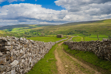 Fototapeta na wymiar On the Coast to Coast long distance footpath walk at Muker in Swaledale in the Yorkshire Dales