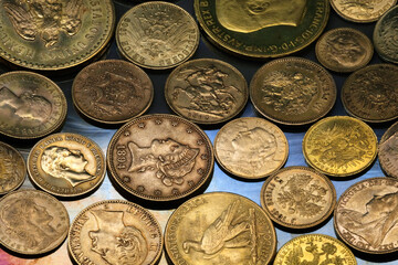 Internationale Goldmünzen liegen dicht an dicht auf opalisierender Oberfläche