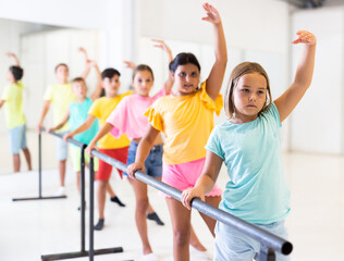 Children exercising ballet moves during their group training.