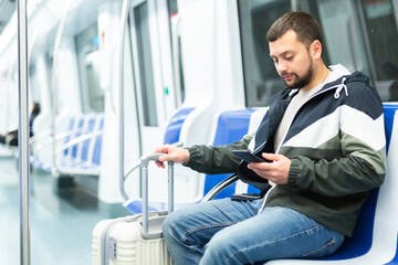 Male passenger in casual clothing talking on his mobile phone in subway