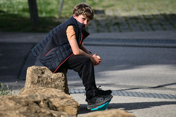 enfant douze ans assis avec son skateboard