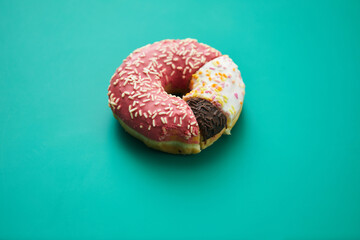 Close-up of sweet pie chart made of various doughnuts with toppings and sprinkles on green...