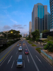 urban road traffic with view of tall buildings and blue clouds