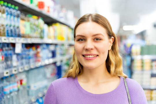 Woman is standing glad after shopping in modern supermarket. High quality photo