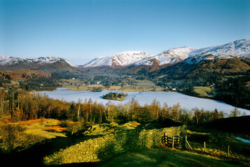 North over Grasmere valley village in Lake District National Park, Cumbria, England. Frozen lake and snow on mountains. Winter.