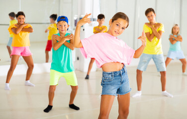 Group of children are learning dance moves in a modern studio