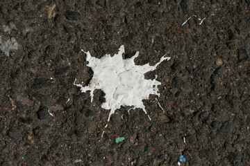White Paint drops on the asphalt ground. Graffiti spray stain on the grey ground. Backround. Closeup. Copy Spase