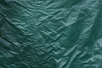 Front view of the green plastic cover of a greenhouse. Background texture of a green grid polyethylene,plastic transparent black plastic film,transparent stretched background