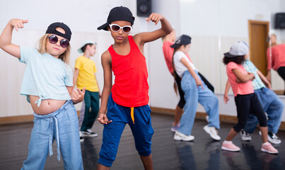 Portrait of confident preteen white girl and afro boy breakdancers in dance studio with dancing...