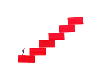 Career ladder concept.Career growth concept. Figurine of a businessman on a red step ladder isolated on a white background