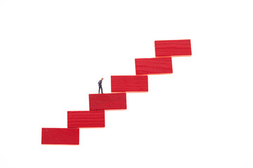 Career.Career ladder concept.Career growth concept. Figurine of a businessman on a red step ladder