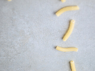 Uncooked Noodles Closeup Gray Concrete - Italian food yellow raw uncooked vermicelli, macaroni, noodle, pastry, pasta on isolated gray cement