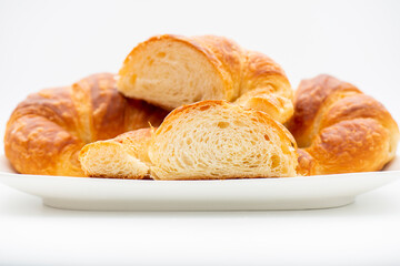 Detailed and closeup photo of a fresh baked plain buttery and flaky croissant.