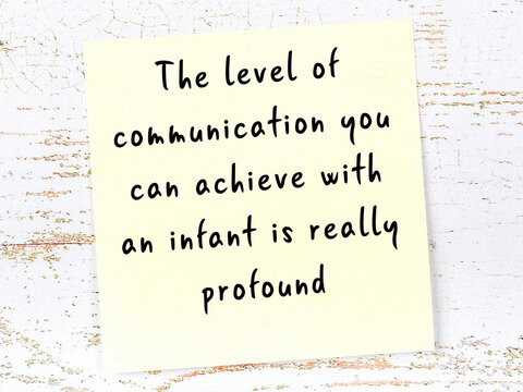 Yellow sticky note on wooden wall with wise quote