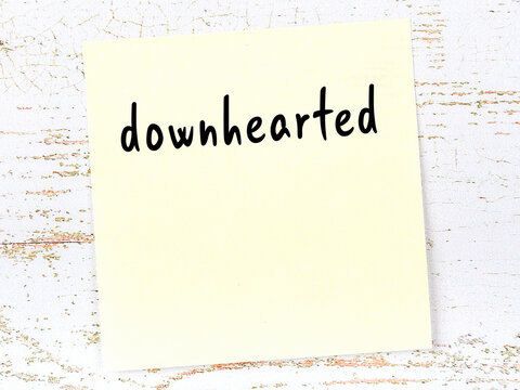 Yellow sticky note on wooden wall with handwritten word unspeakable