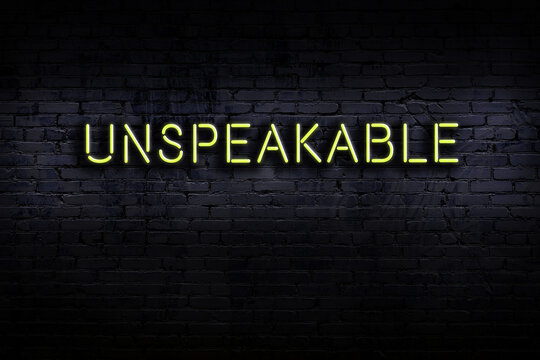Night view of neon sign on brick wall with inscription unspeakable