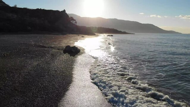 Aerial View Of The Calm Sea Beach With Rocks And Waves In The Morning Sunlight