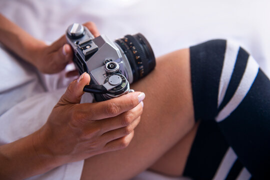 photographer girl in black stockings and an old analog camera in her hand