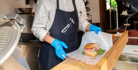 サンドイッチを作るカフェ・レストランの店員