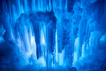 Beautiful gigantic icicles at night in winter forming a blue abstract art sculpture - Powered by Adobe