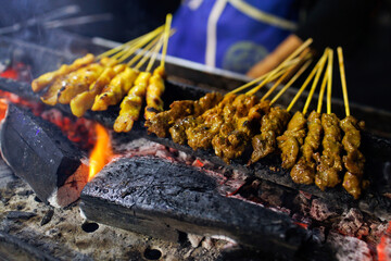 Chicken satay in grilling place with smoke. Traditional satay from java, Indonesia.