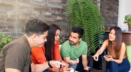 group of young friends hanging out and looking at the cell phone