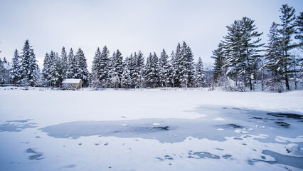 Frozen pond in the countryside near Tremblant ski resort on a cold and snowy winter day in Quebec...