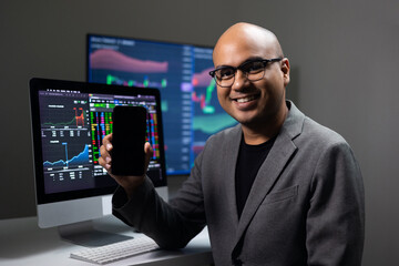 Financial analyst with exchange rate diagram on smartphone in neon light. Investor businessman analyzing a graphic of a stock cryptocurrency exchange chart with cell phone. Investment concept