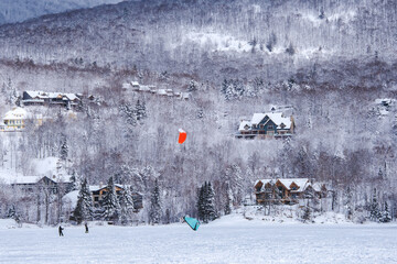 People snowkiting on a cold winter day on Lake Tremblant near Tremblant ski resort in Quebec (Canada)