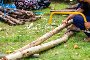 A carpenter is cutting and constructing a large tree crutches.