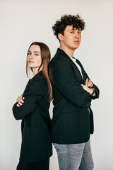 Vertical portrait young attractive dark-haired man and woman in black clothes standing back to back on white back view