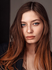 Naklejka premium Close up portrait of joyless 20-25s woman standing alone. Face serious female with sad eyes staring at camera. vertical